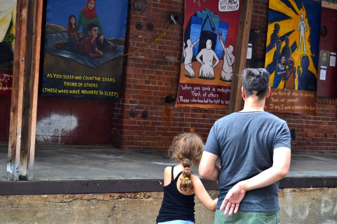 Photo of a father and child viewing the "Think of Others" exhibit at Art Hop.